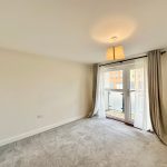 Bright empty room with carpet and balcony access