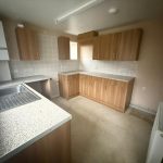 Empty kitchen with wooden cabinets and countertops.