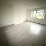 Empty room with large window and wooden floor