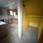 Kitchen with wooden cabinets and yellow storage area.