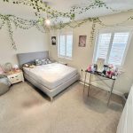 Bright bedroom with plants and modern decor.