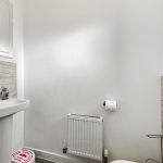 Modern bathroom with sink, mirror, radiator.