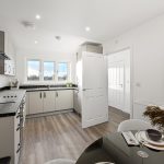 Modern kitchen with wooden floor and natural light.