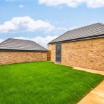 Back garden with brick sheds and lawn