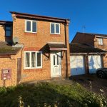 Brick house with driveway and garage in sunshine
