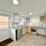 Modern kitchen design with wooden cabinets and appliances.