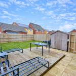 Backyard with patio, shed, and garden furniture.