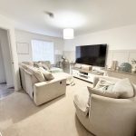 Modern living room with sofa and large TV.