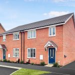Modern semi-detached red brick house with blue doors.