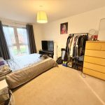 Cosy bedroom with bed, TV, wardrobe and drawers.