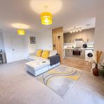 Modern open-plan living room with kitchen area.