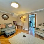 Cosy living room with sofas and wooden flooring.