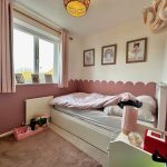 Cosy children's bedroom with pink decor and toys.