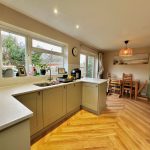 Modern kitchen with dining area, wooden flooring.