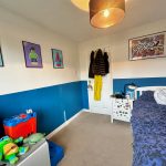 Colourful bedroom with superhero posters and toys.