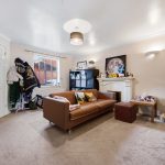 Cosy living room with brown sofa and fireplace.
