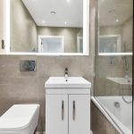 Modern bathroom with shower, sink, and toilet.