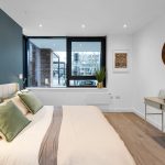 Modern bedroom with large windows and stylish decor.