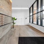 Lobby with mailboxes and large windows near street