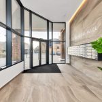 Modern building entrance with large windows and letterboxes.