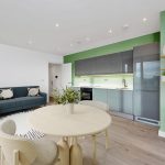 Modern flat with green kitchen and stylish sofa
