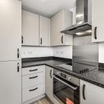 Modern kitchen with stove and cabinets.