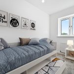 Child's bedroom with bed and colourful cushions.