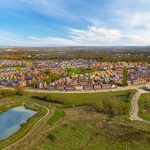 Aerial view of suburban houses and green landscape.