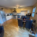 Modern kitchen with dining table and appliances.