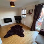 Modern living room with wood flooring and large window.