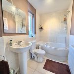 Modern bathroom with sink, bathtub, and toilet.