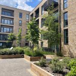 Modern brick apartment building with landscaped courtyard.