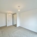 Empty room with white walls and carpet floor.
