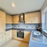 Modern kitchen with wooden cabinets and stainless steel sink.