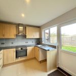 Modern kitchen with wooden cabinets and garden view