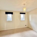 Empty room with carpet and two windows