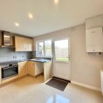 Modern kitchen with wooden cabinets and appliances.