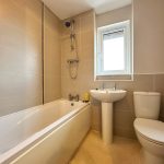 Modern bathroom with bathtub, shower, toilet, and sink.