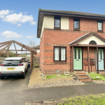 Brick semi-detached house with cars in driveway.