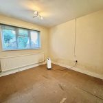 Empty room with dehumidifier, light, and window view.