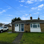 Single-storey house with parked white SUV.