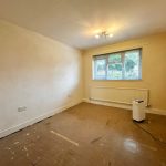 Empty room with beige walls and large window.
