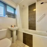 Modern bathroom with bathtub, sink, and toilet.