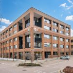 Modern brick office building on street corner.