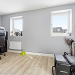 Modern gaming setup with guitar on wall.