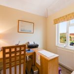 Bright home office with desk and window view.