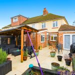 Cosy backyard with pergola and potted plants.