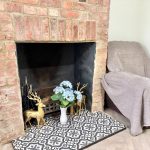 Brick fireplace with flowers and statue deer ornament.