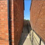 Narrow alleyway between two brick buildings.