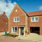 Modern red-brick house with garage and driveway.